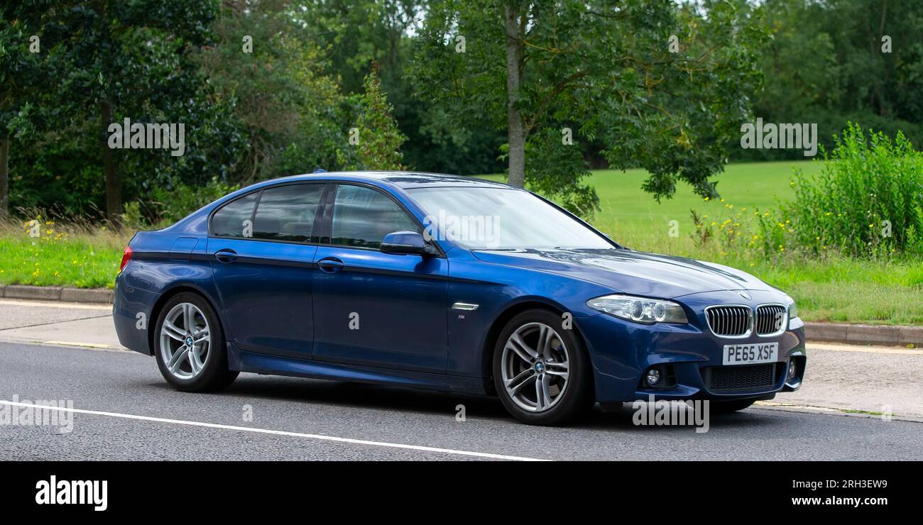 Milton Keynes,UK - Aug 13th 2023:Blue diesel engine 2015 BMW 520 d m sport  car driving on an English country road. Stock Photo