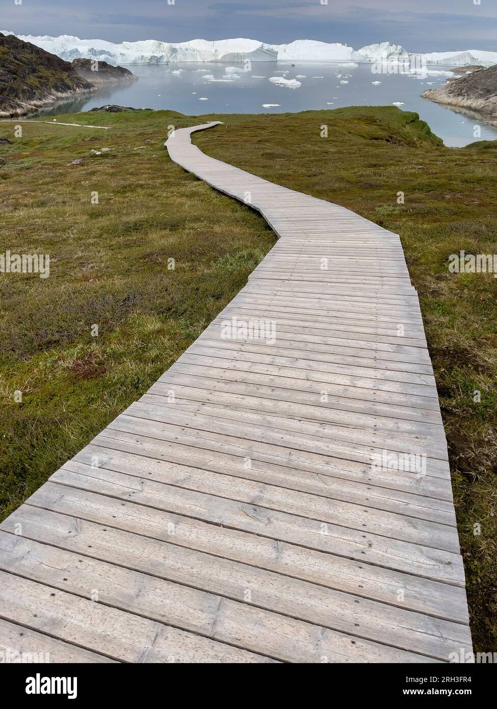 Greenland, Ilulissat, Disko Bay. Wooden walkway leading to Ilulissat Ice Fjord, Sermermiut Trail. UNESCO World Heritage Site. Stock Photo
