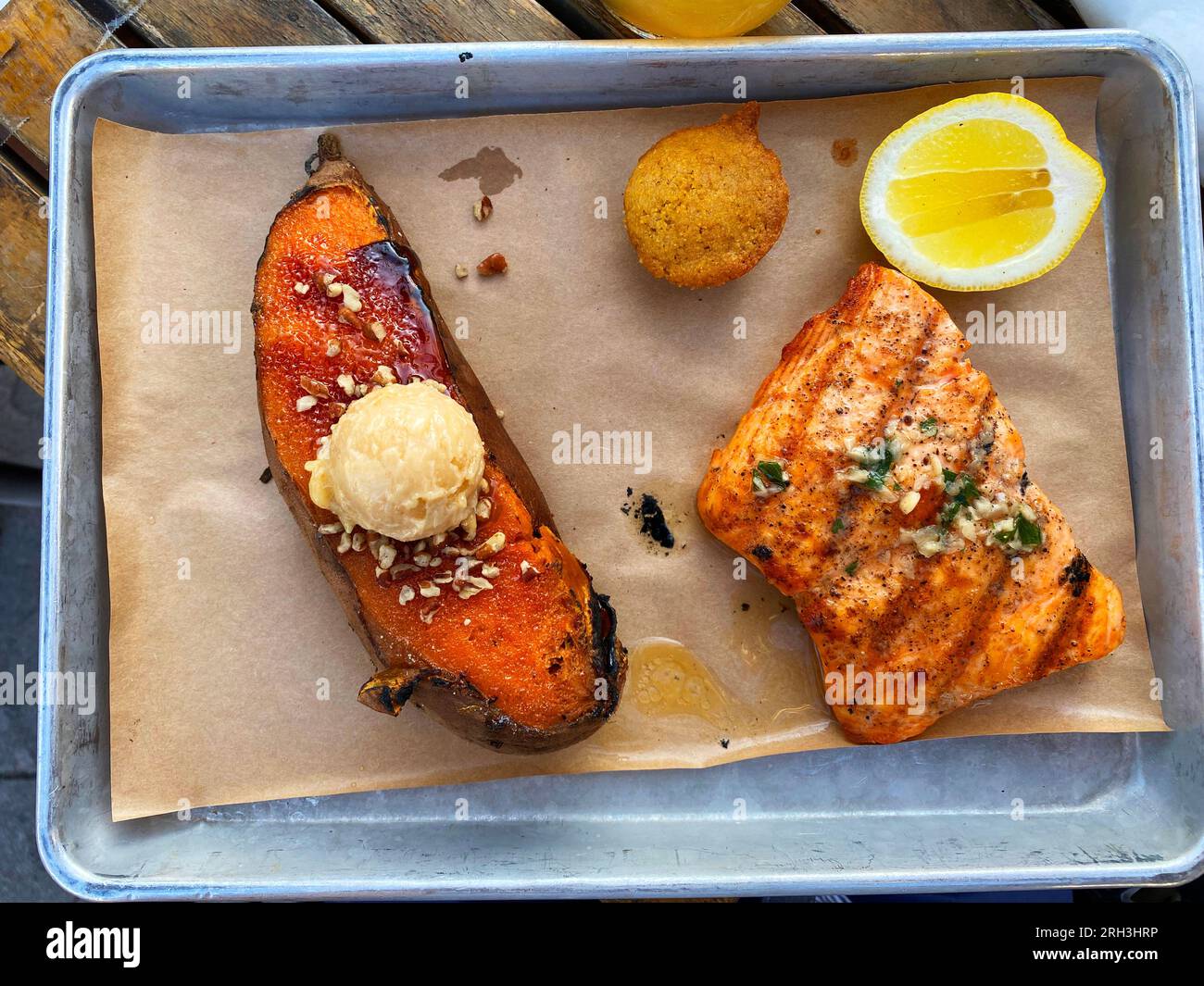 Top-down view of salmon and sweet potato on metal cafeteria tray Stock Photo