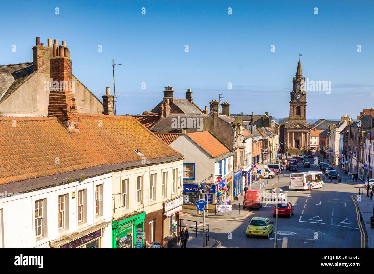 14 April 2016: Berwick-on-Tweed, Northumberland, UK - Marygate, busy with shoppers,traffic and a bus, and the Town Hall with its historic clock tower. Stock Photo