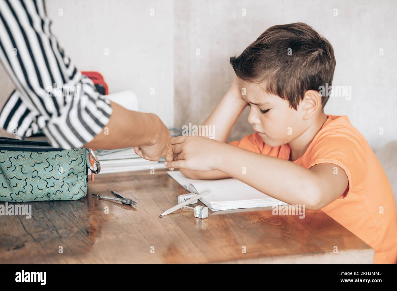 Mom ordering her schoolboy to do his homework Stock Photo