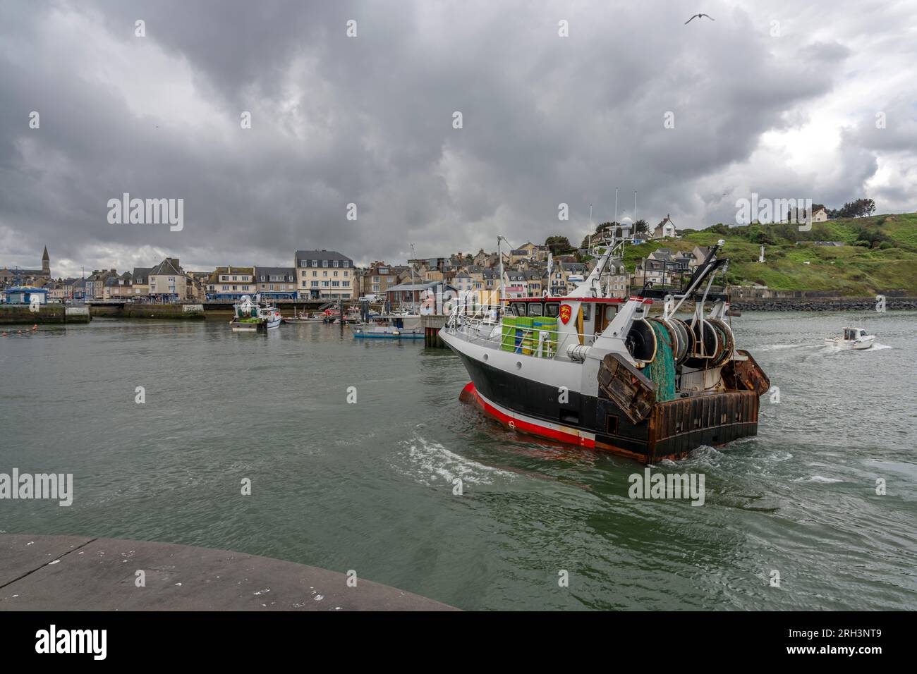 Port-en-Bessin-Huppain, France - 07 24 2023: Panoramic view of the harbor, the pier, boats, the city and the cliff Stock Photo