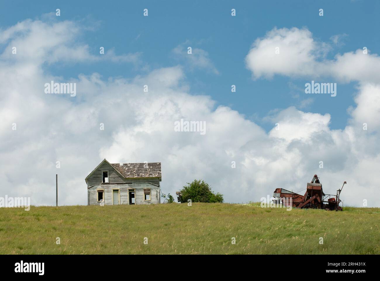 Abandoned farmhouse and the rusting remains of old farming equipment. Whitman County, Washington, USA. Stock Photo
