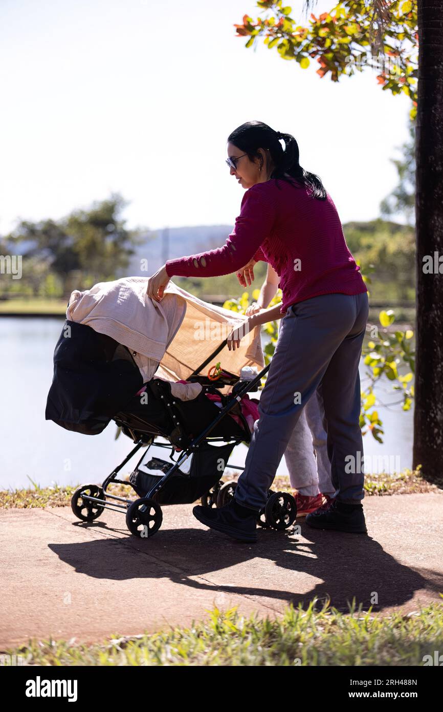 closeup of baby stroller with newborn baby being carried by mother
