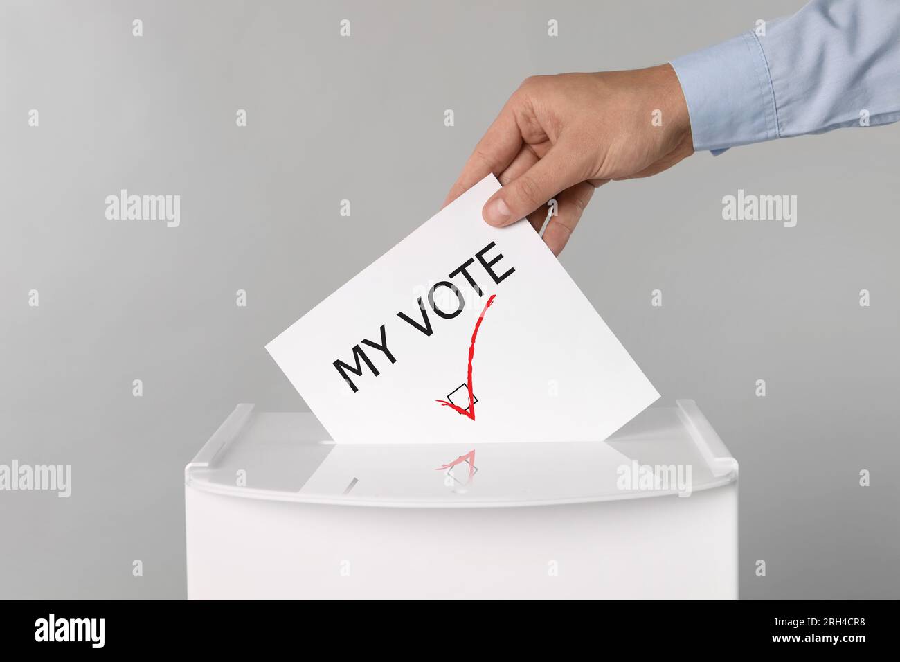 Man putting paper with text My Vote and tick into ballot box on light ...