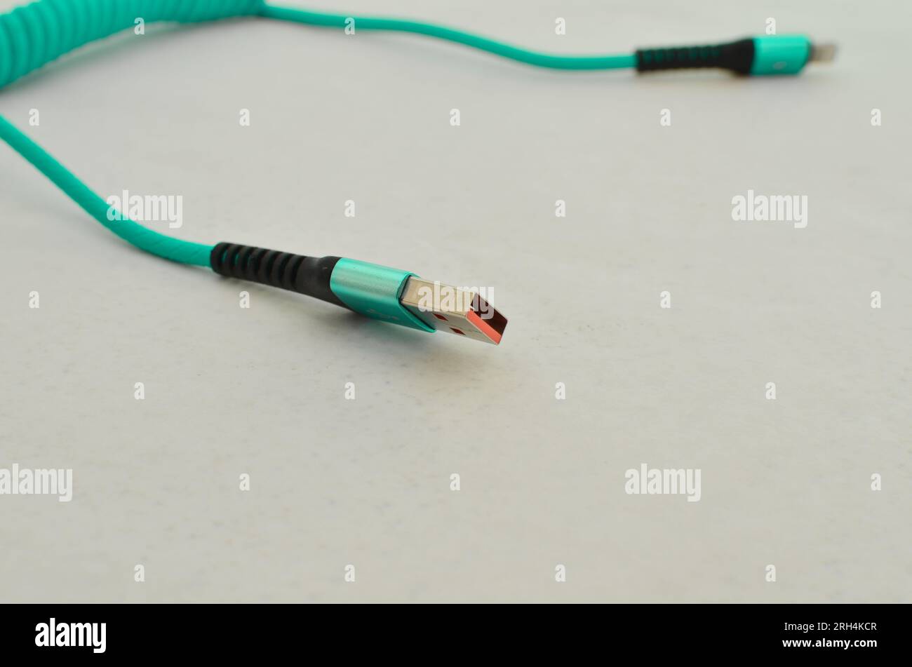 USB cable connection detail highlighted on a clear surface, perfect for modern technology concepts. Cable that provides speed and data transfer. Stock Photo