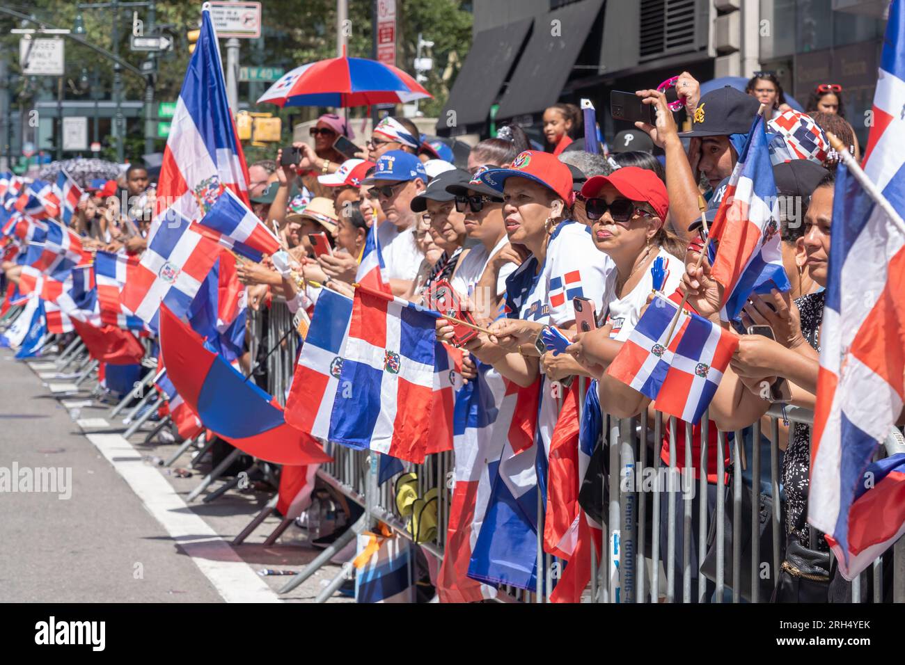 New York, New York, USA. 13th Aug, 2023. (NEW) 41st National Dominican Day Parade 2023. August 13, 2023, New York, New York, USA: Spectators with Dominican Republic flags watch the marchers at the Dominican Day Parade on 6th Avenue on August 13, 2023 in New York City. The National Dominican Day Parade celebrated 41 years of marching on Sixth Avenue in Manhattan. The parade celebrates Dominican culture, folklore, and traditions. Credit: ZUMA Press, Inc./Alamy Live News Stock Photo