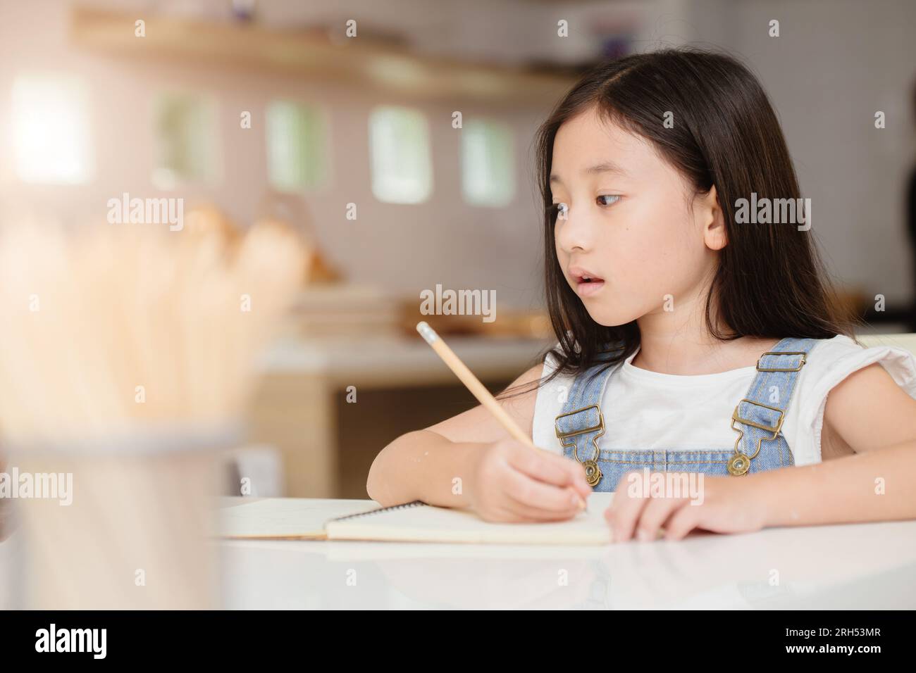 Cute child girl happy learning education doing home work at home holiday Stock Photo