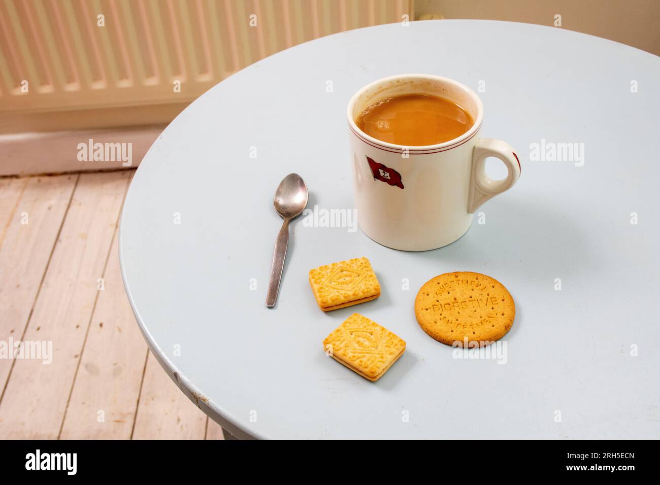 A mug of strong tea and three biscuits waiting for a very British moment of refreshment Stock Photo