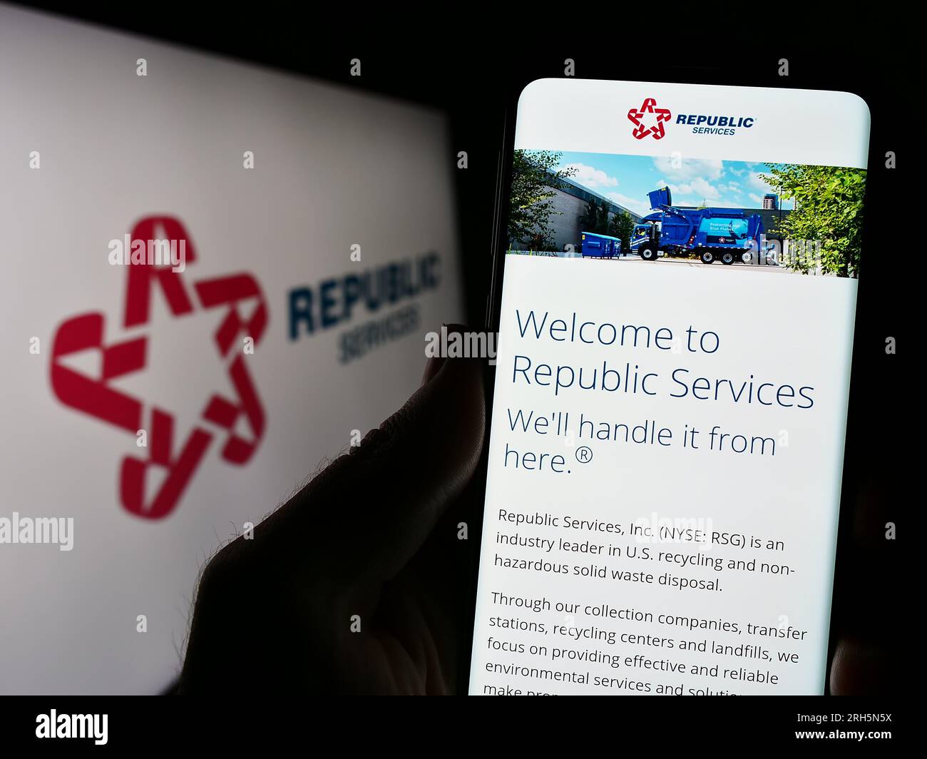 Person holding cellphone with webpage of US waste disposal company Republic Services Inc. on screen with logo. Focus on center of phone display. Stock Photo