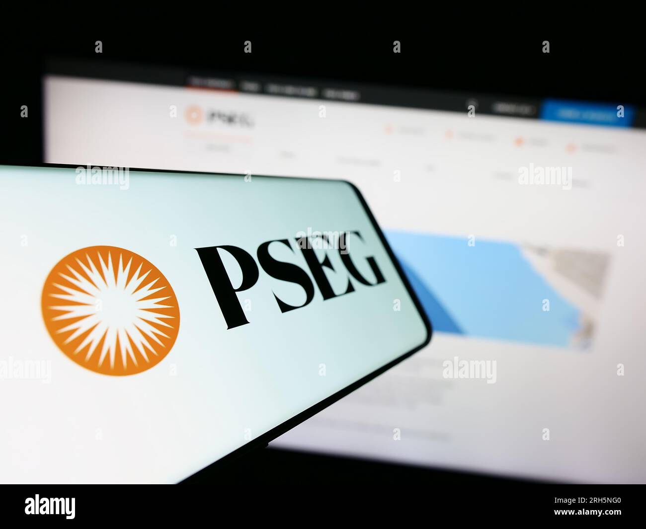 Mobile phone with logo of company Public Service Enterprise Group (PSEG) on screen in front of website. Focus on center-left of phone display. Stock Photo
