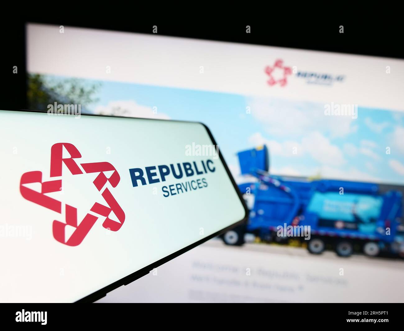 Mobile phone with logo of US waste disposal company Republic Services Inc. on screen in front of website. Focus on center-left of phone display. Stock Photo