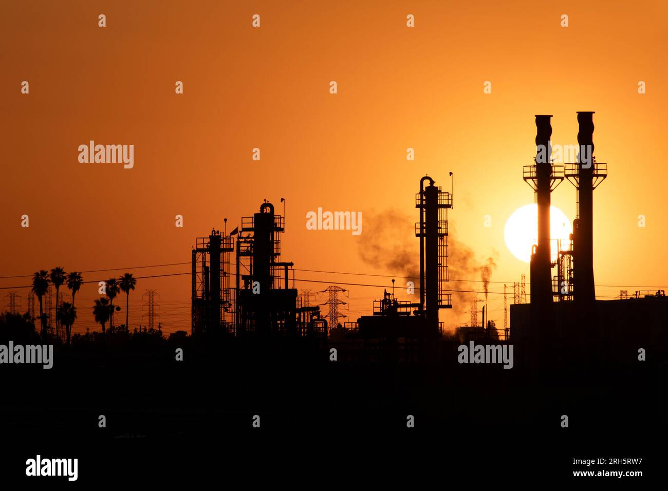 Sun sets on industrial complex orange sky Stock Photo - Alamy