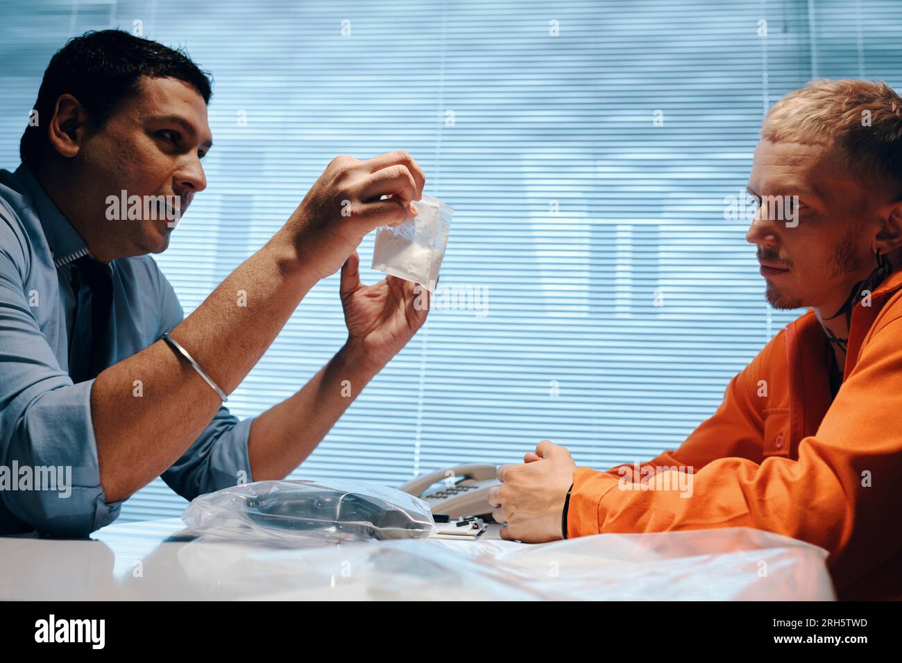 Police officer showing arrested drug dealer two bags of white powder ...