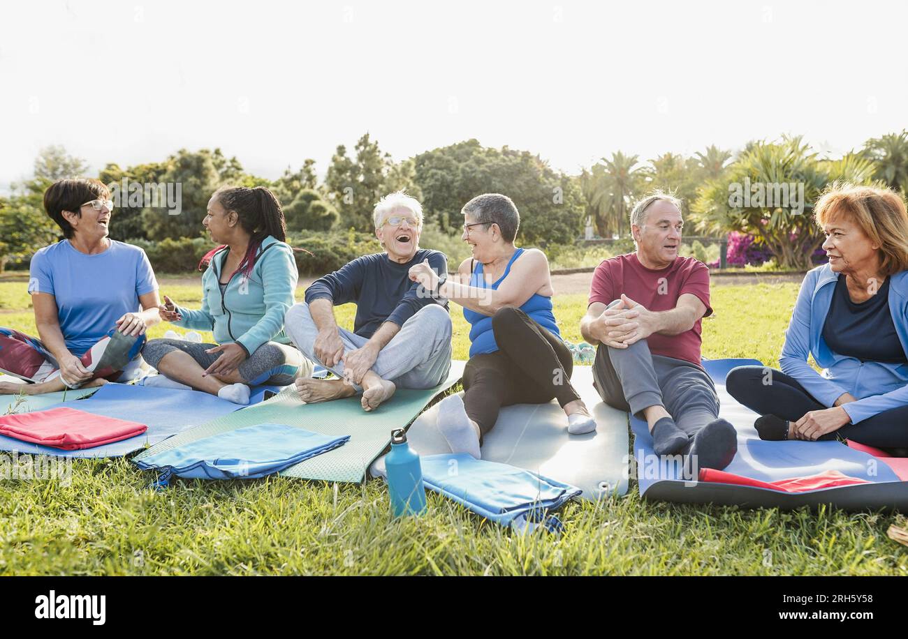 Mature old people having fun after yoga class outdoor - Joyful elderly lifestyle and sport activity concept concept - Main focus on right faces Stock Photo