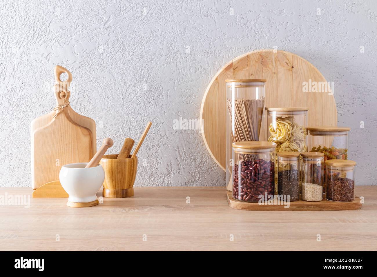 https://c8.alamy.com/comp/2RH60B7/eco-friendly-tools-on-the-kitchen-wooden-countertop-against-a-gray-textured-wall-jars-for-storing-bulk-products-modern-kitchen-space-2RH60B7.jpg
