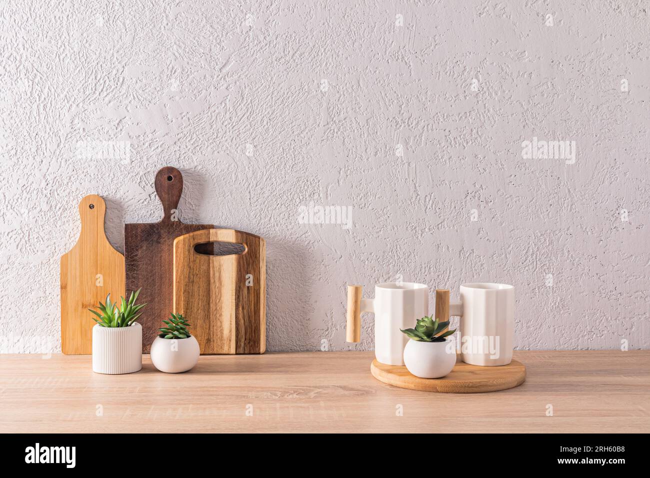 Beautiful kitchen background in a minimalist style with two stylish ceramic  mugs and a set of different wooden cutting boards. front view Stock Photo -  Alamy, image size:1300x956