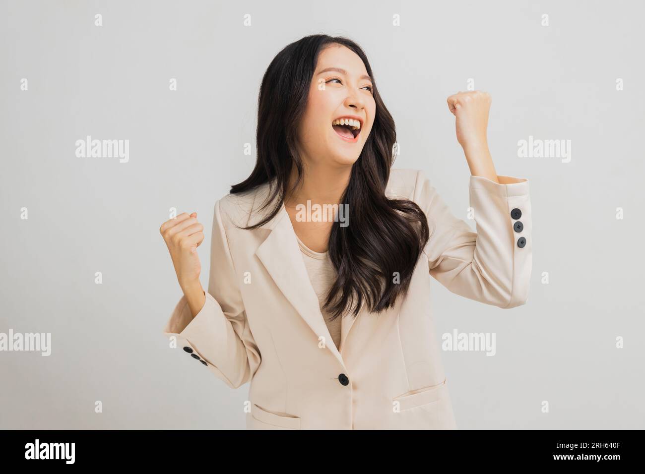 Successful and attractive Asian businesswoman show hand up to celebrate, success and glad woman in white suit isolated in studio Stock Photo