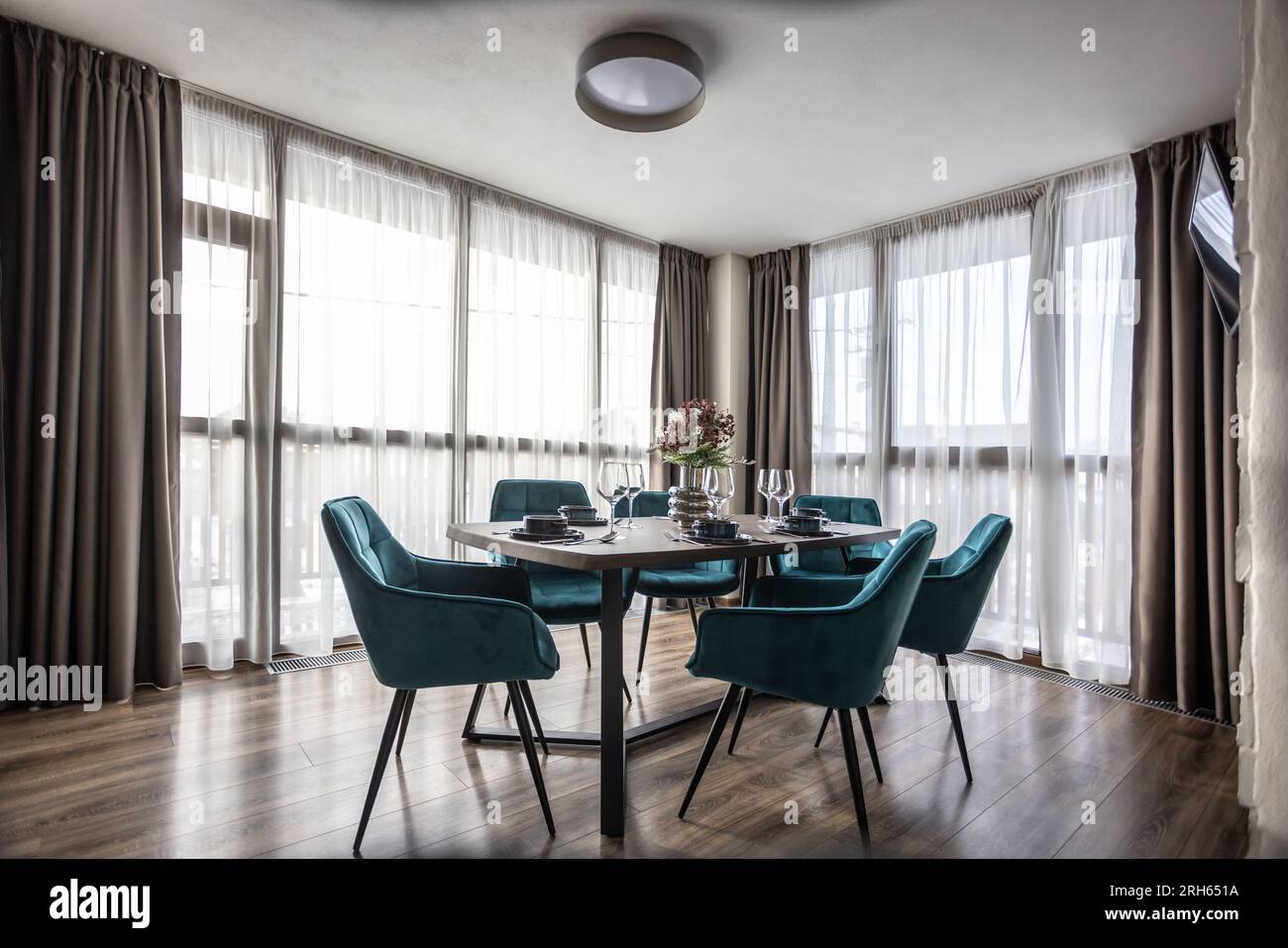Dining room with wooden table and blue chairs floor in modern apartment. Stock Photo