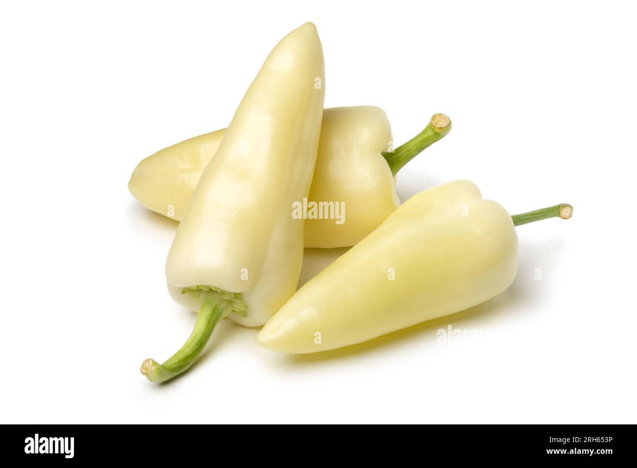 Heap of whole fresh raw white pointed bell peppers isolated on white background close up Stock Photo
