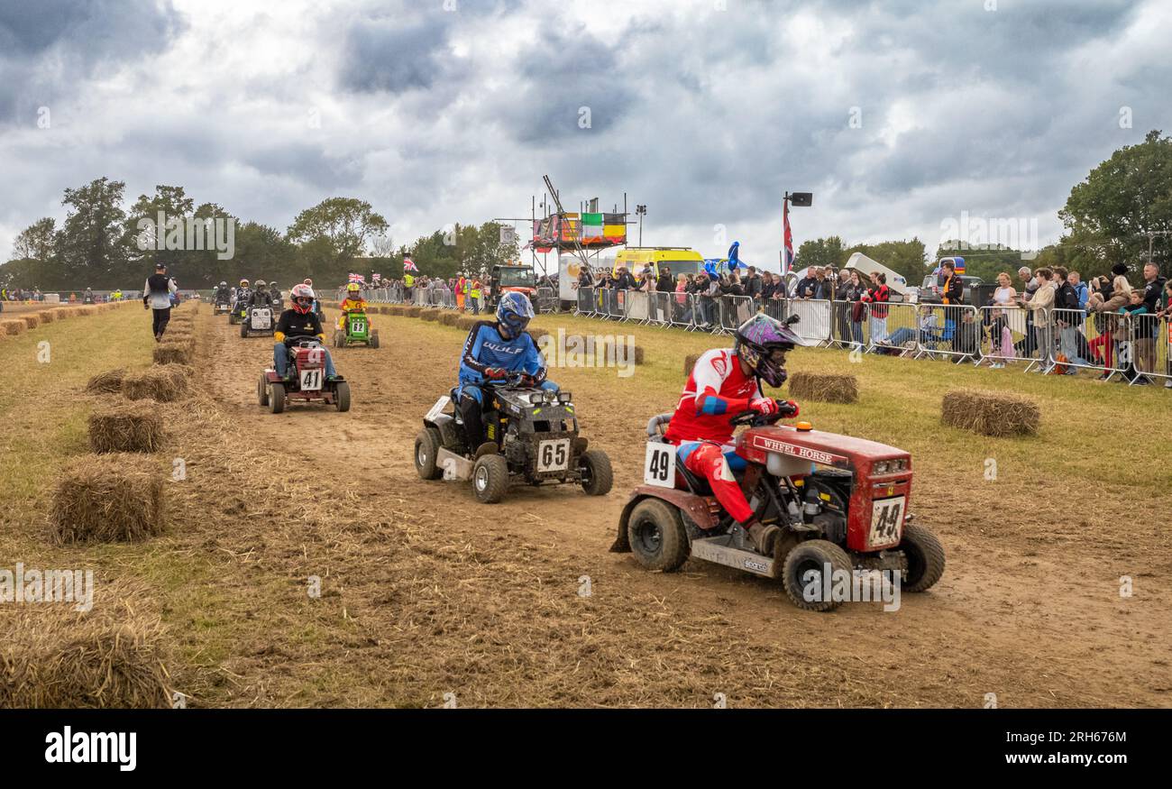 More than 50 racing lawn mowers are driven in a warm up lap in front of spectators before the start of the Le Mans style annual British Lawn Mower Rac Stock Photo