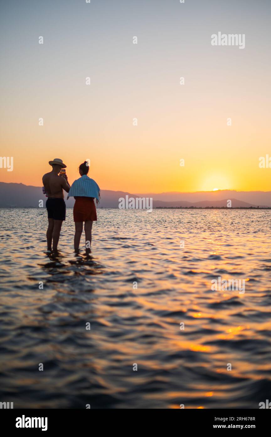 People enjoying sunset at Trabucador beach, Ebro Delta, Tarragona, Spain Stock Photo