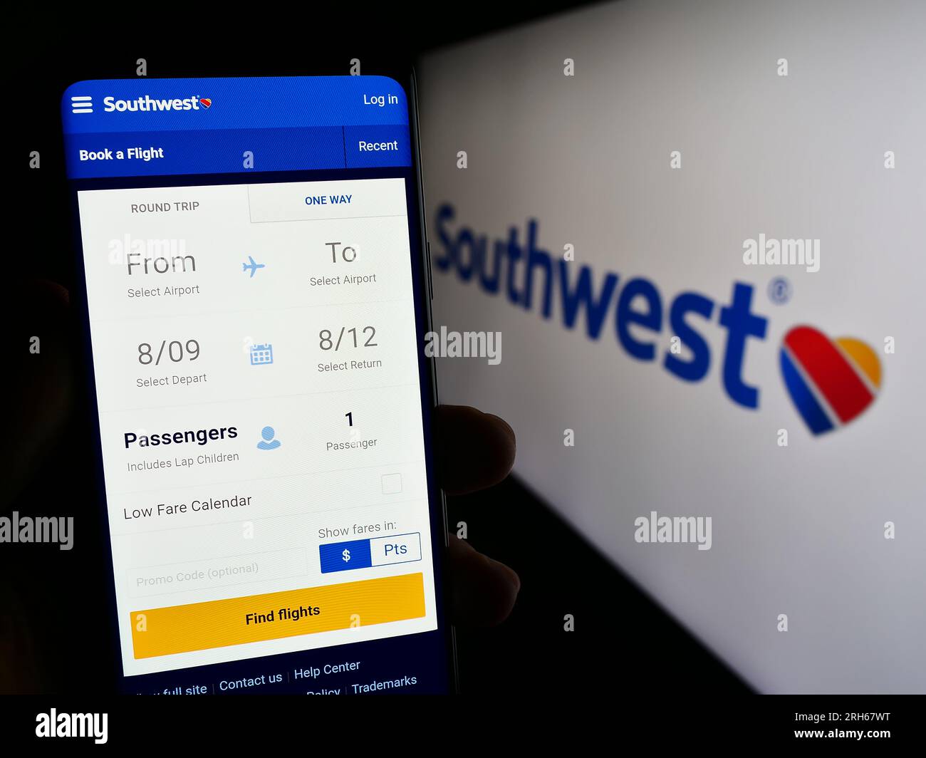 Person holding mobile phone with web page of US airline company Southwest Airlines Co. on screen with logo. Focus on center of phone display. Stock Photo