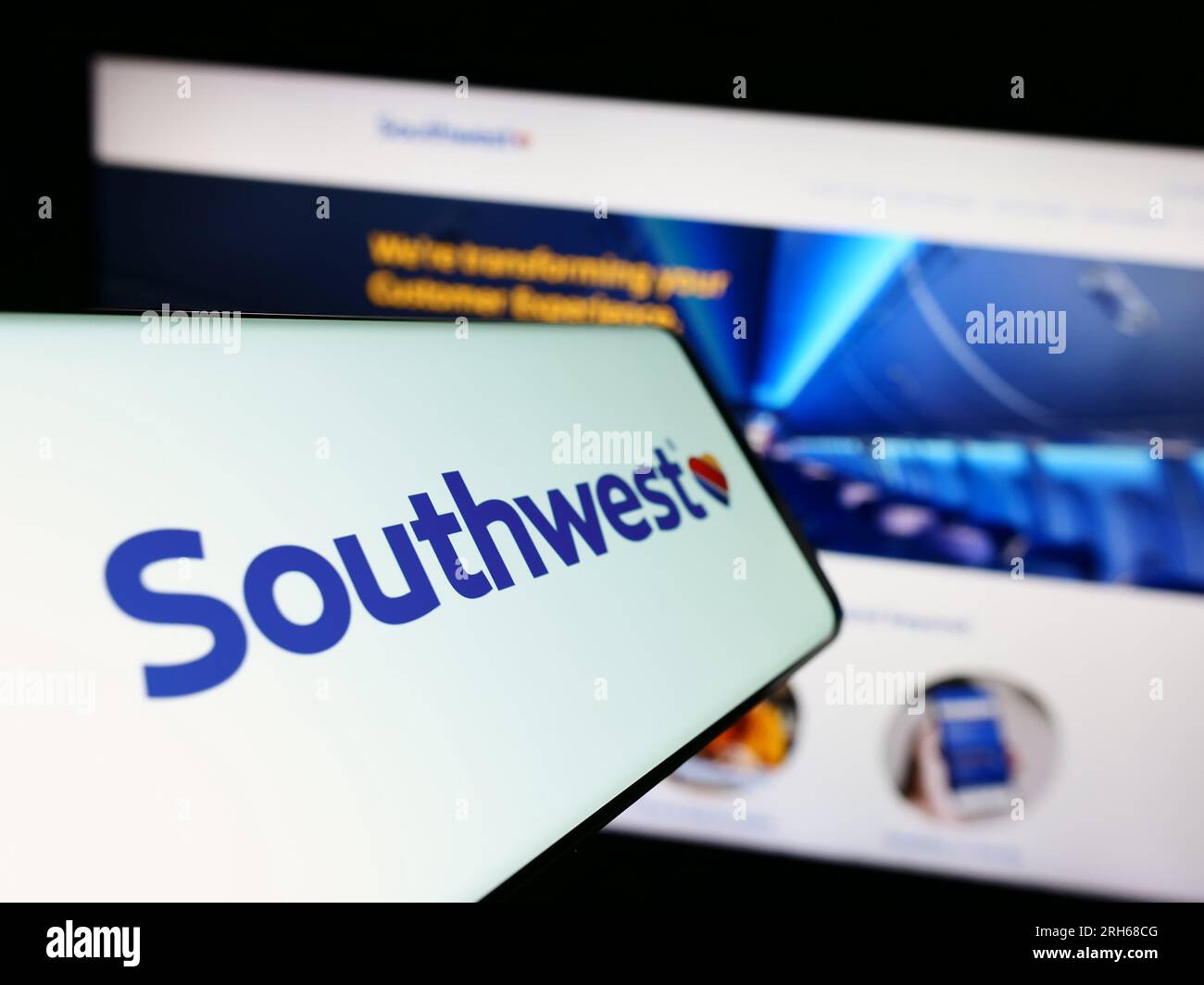 Mobile phone with logo of American airline company Southwest Airlines Co. on screen in front of website. Focus on center of phone display. Stock Photo