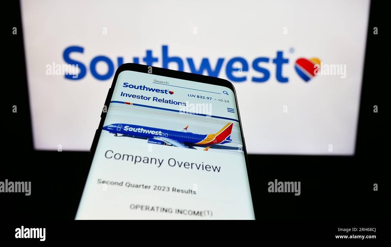 Smartphone with website of US airline company Southwest Airlines Co. on screen in front of business logo. Focus on top-left of phone display. Stock Photo