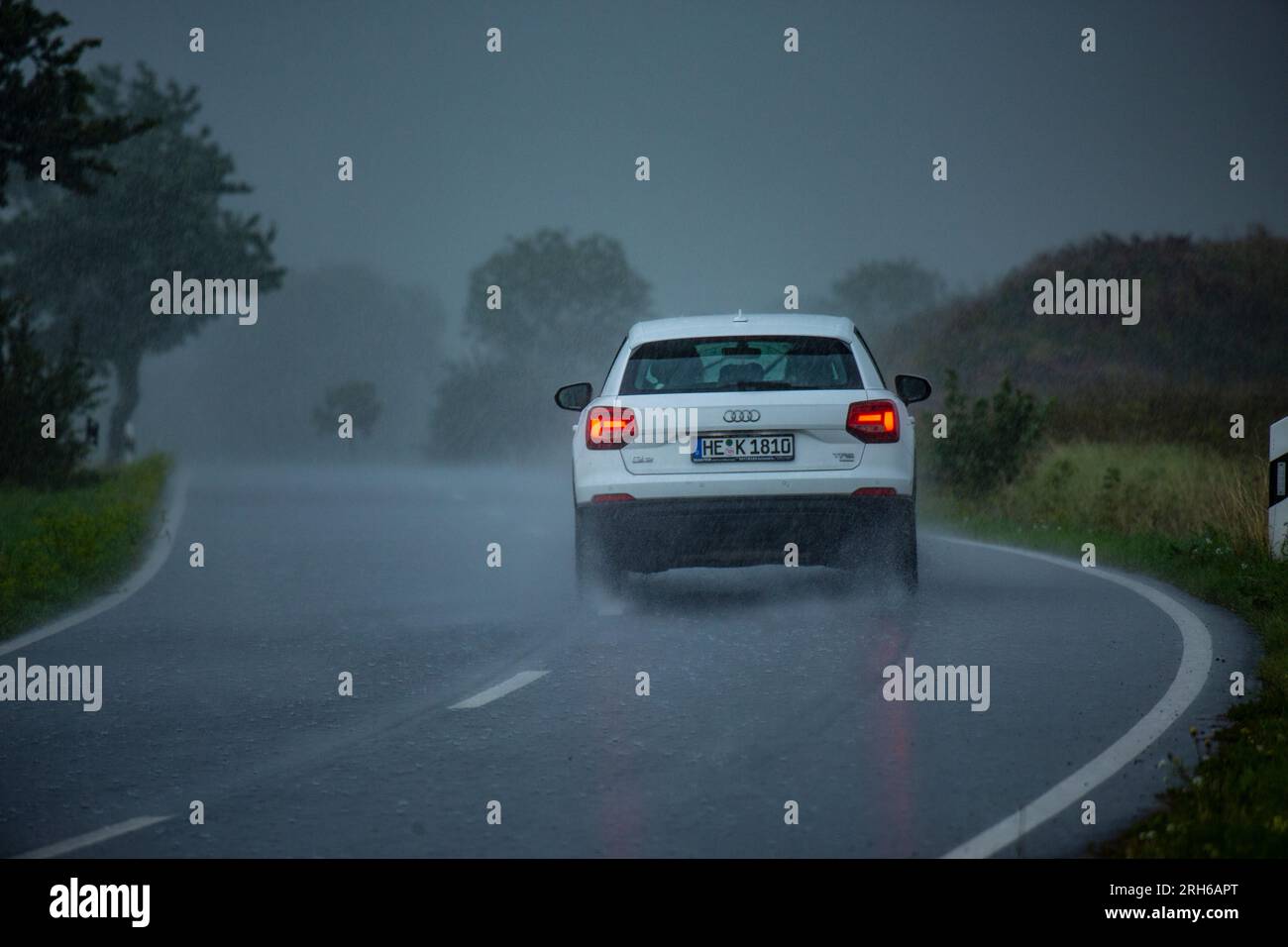 Ein Auto auf einer Landstrasse bei starkem Regen. Stock Photo