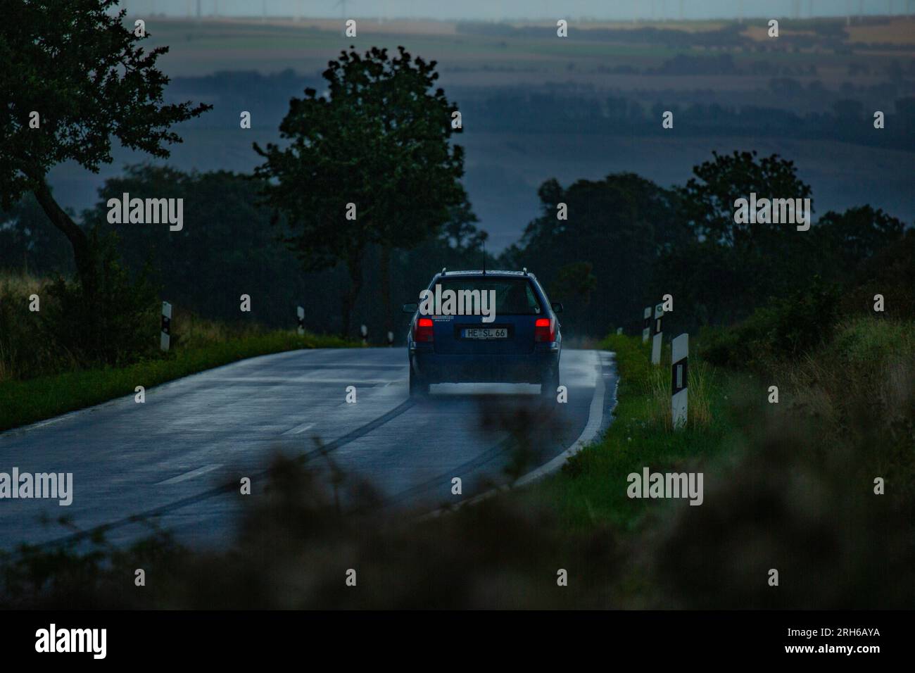 Ein Auto auf einer Landstrasse bei starkem Regen. Stock Photo
