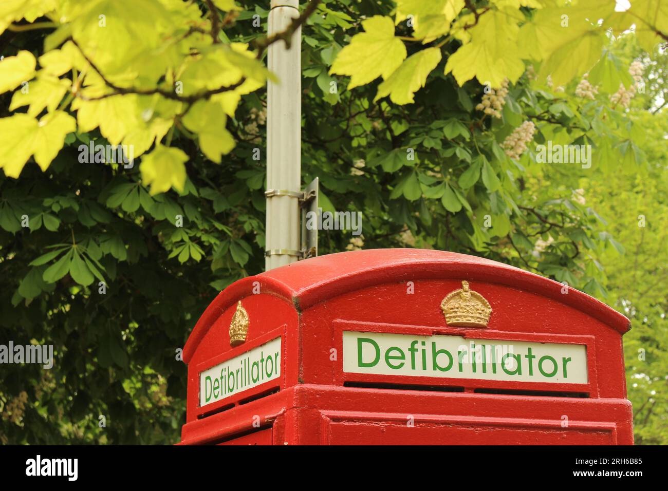 Top of Old Red telephone box converted to hold defibrillator. Typical British telephone booth reimagined as defibrillator station - Cheltenham, UK Stock Photo