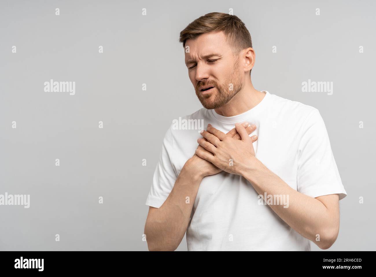 Man holds on to chest, suffering from heartburn. Acute pain