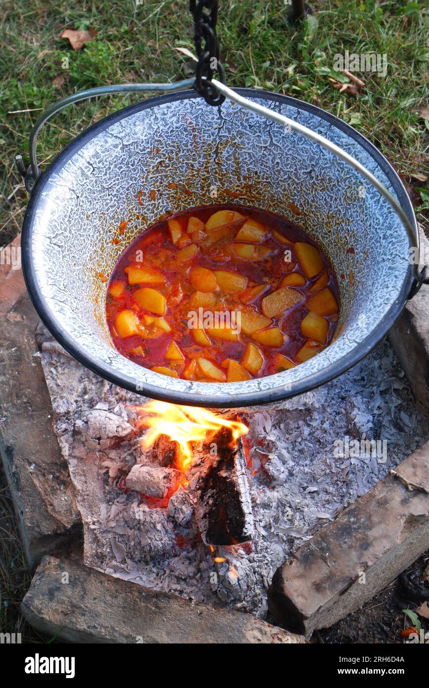 Hungarian paprika potatoes, paprikás krumpli, cooking in a pot, bogracs, over an open fire, Hungary Stock Photo