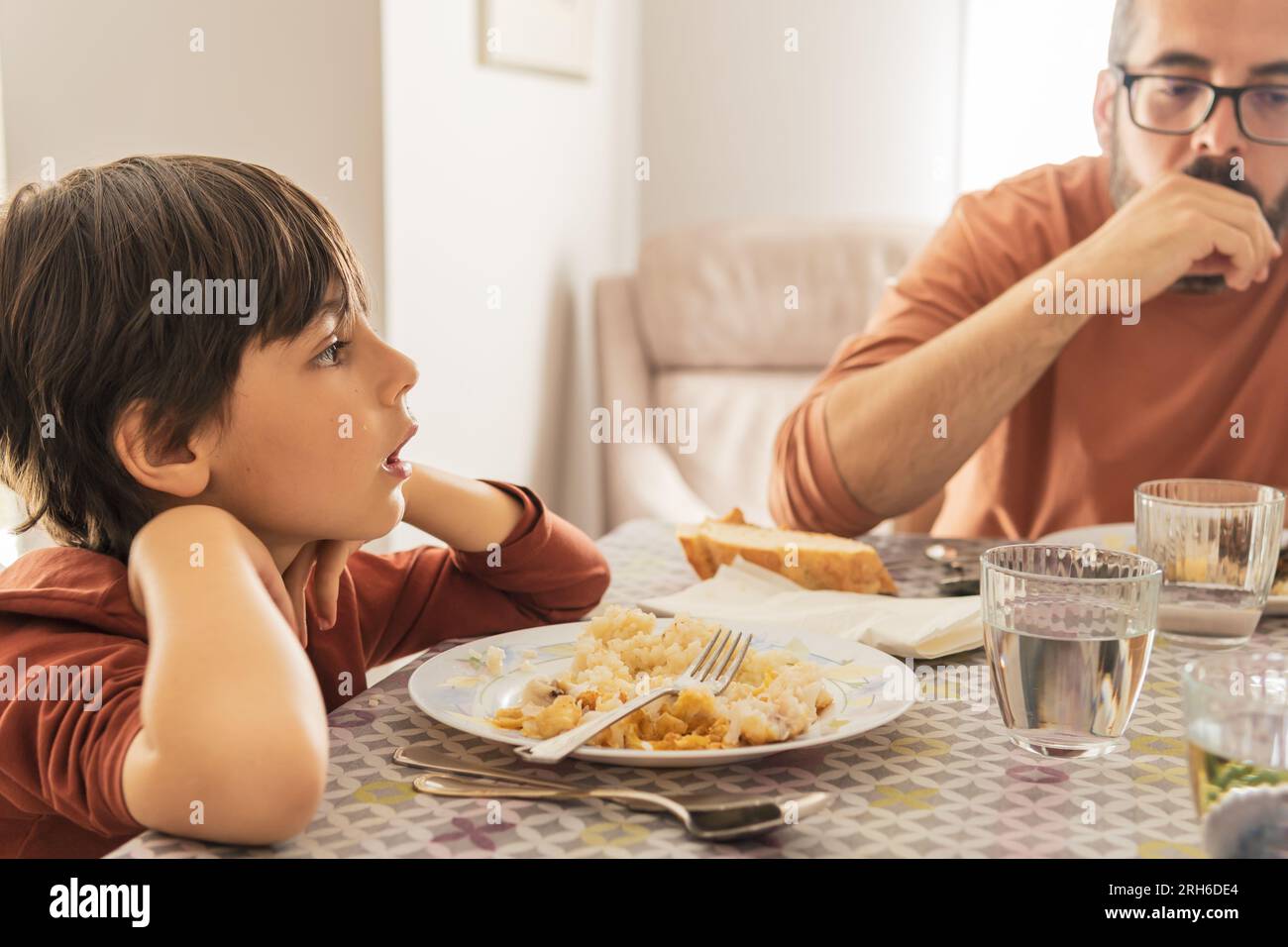 Latin child and father eating spanish meal together Stock Photo