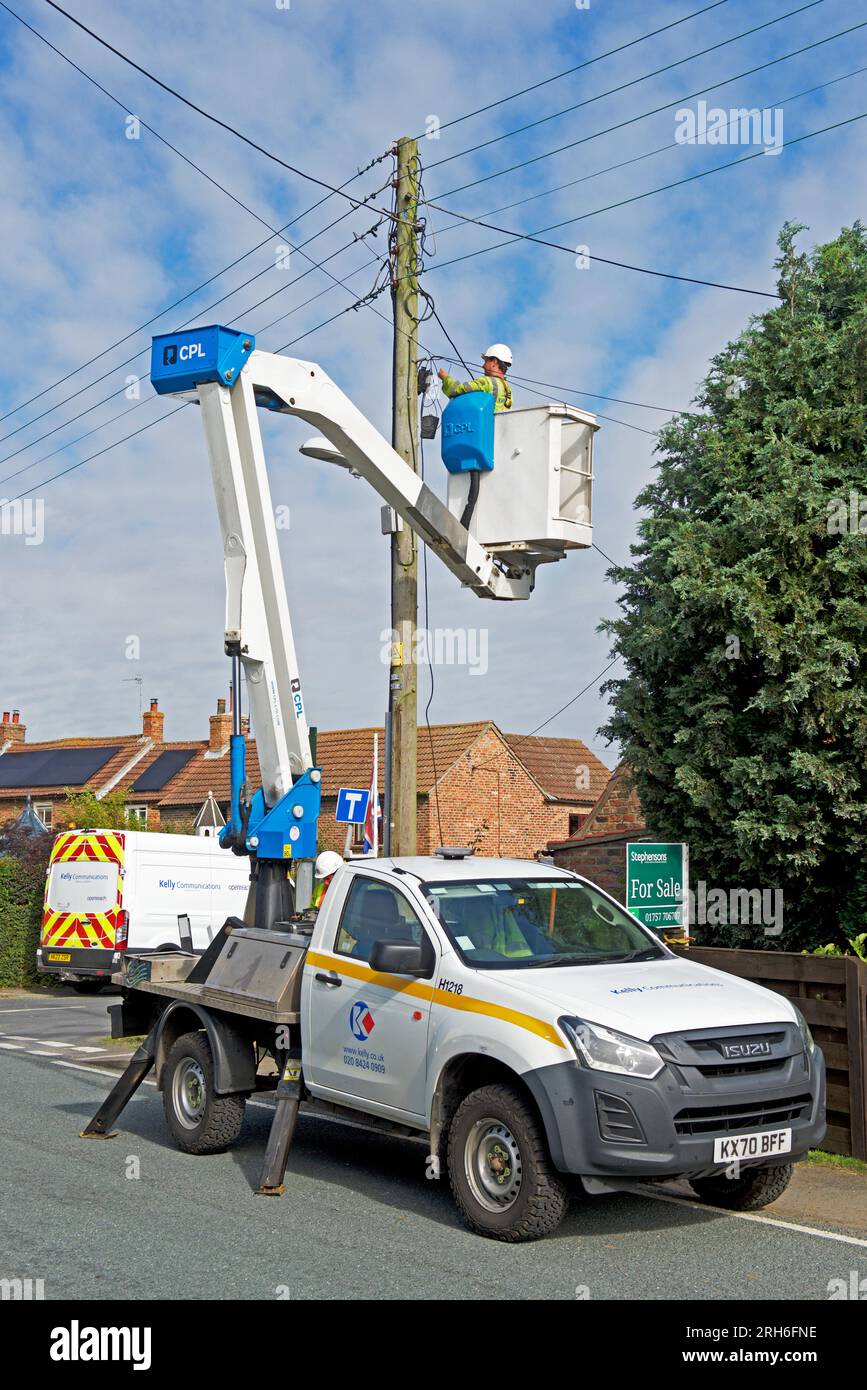 Contractors replacing telegraph poles and wiring in a village, England UK Stock Photo