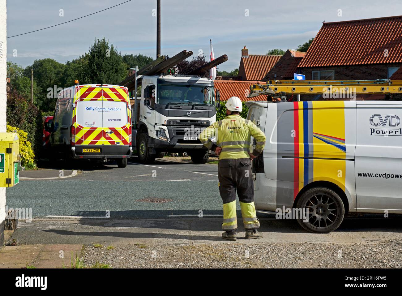 Contractors replacing telegraph poles and wiring in a village, England UK Stock Photo