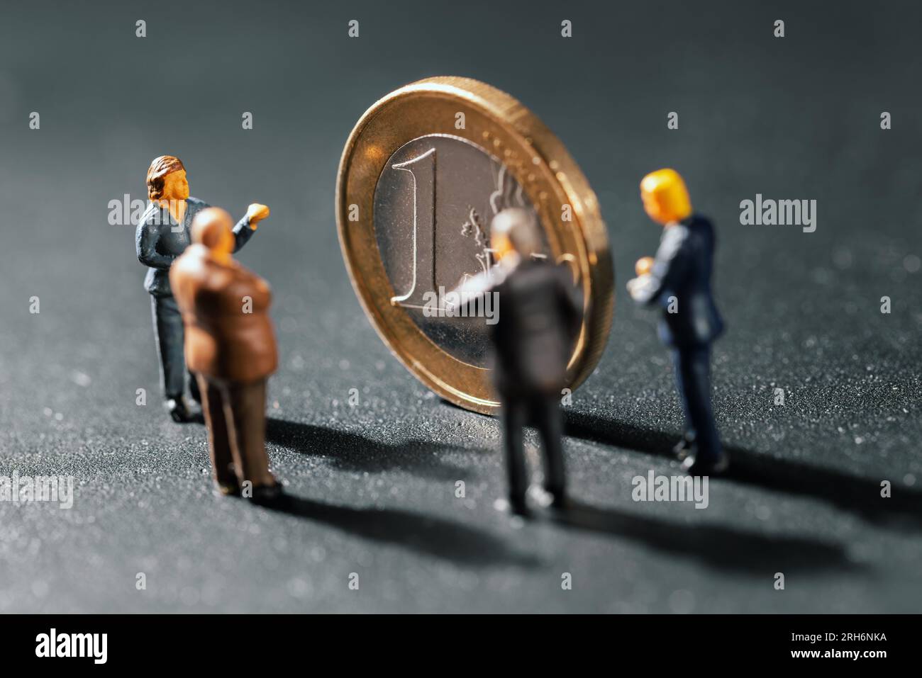 businessmen figurines standing by euro coin. business consulting, investment and management concept Stock Photo