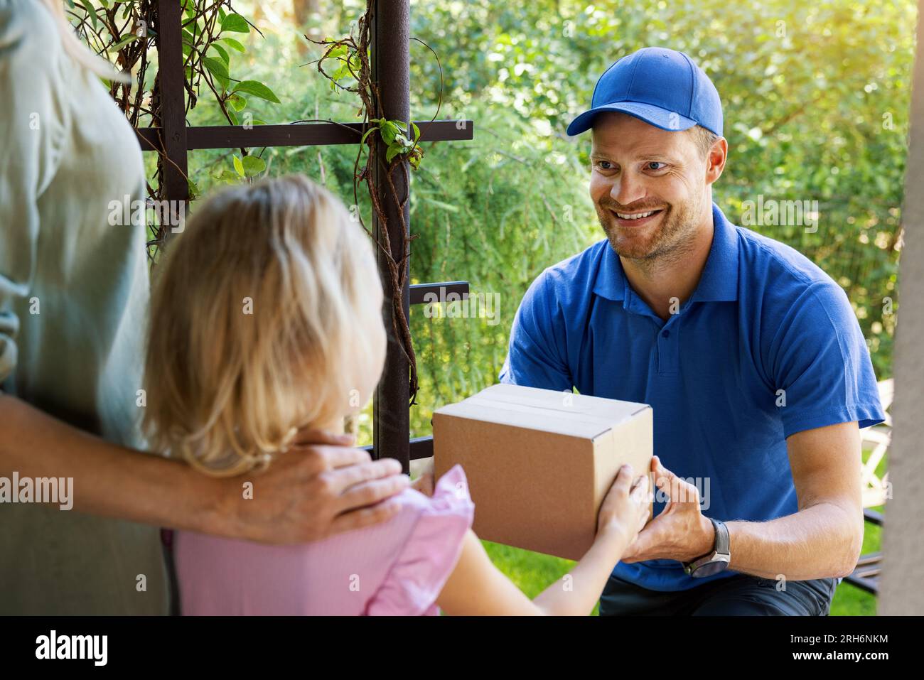 mother with child accepting home delivery package from smiling delivery