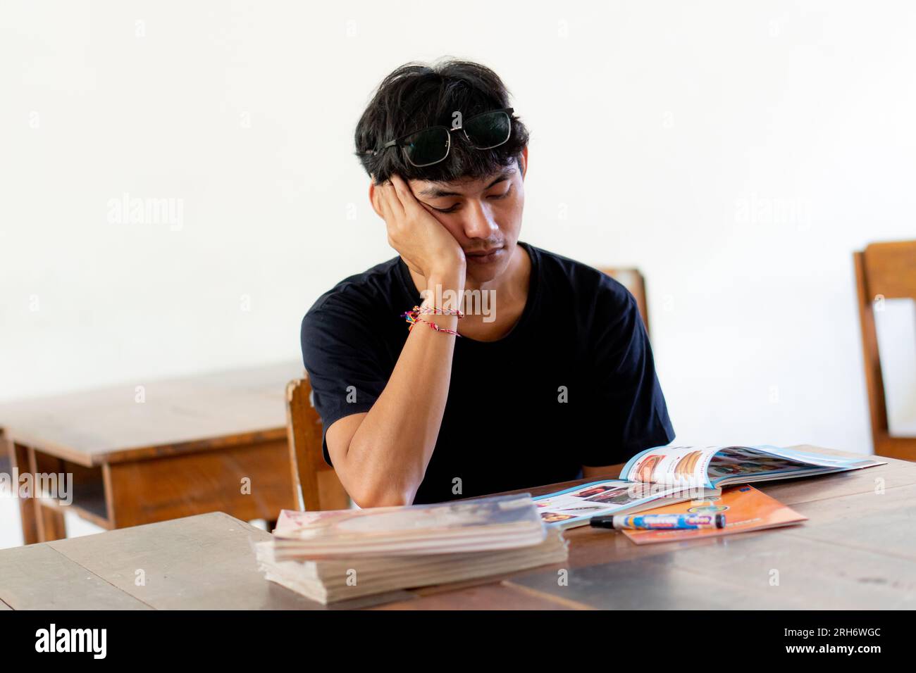 Overworked and tired high school student man studying feeling depressed and desperate Stock Photo