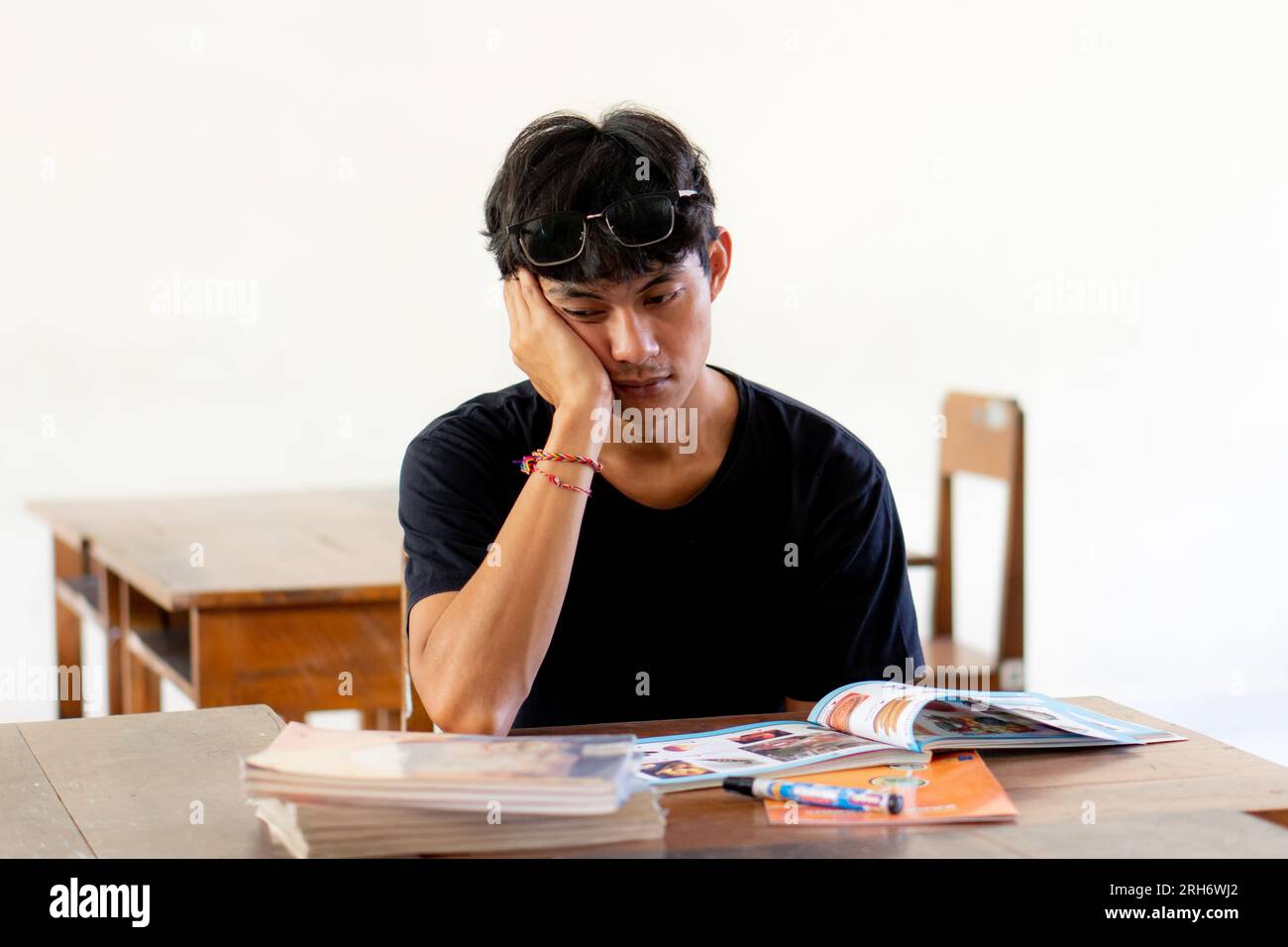 Overworked and tired high school student man studying feeling depressed and desperate Stock Photo
