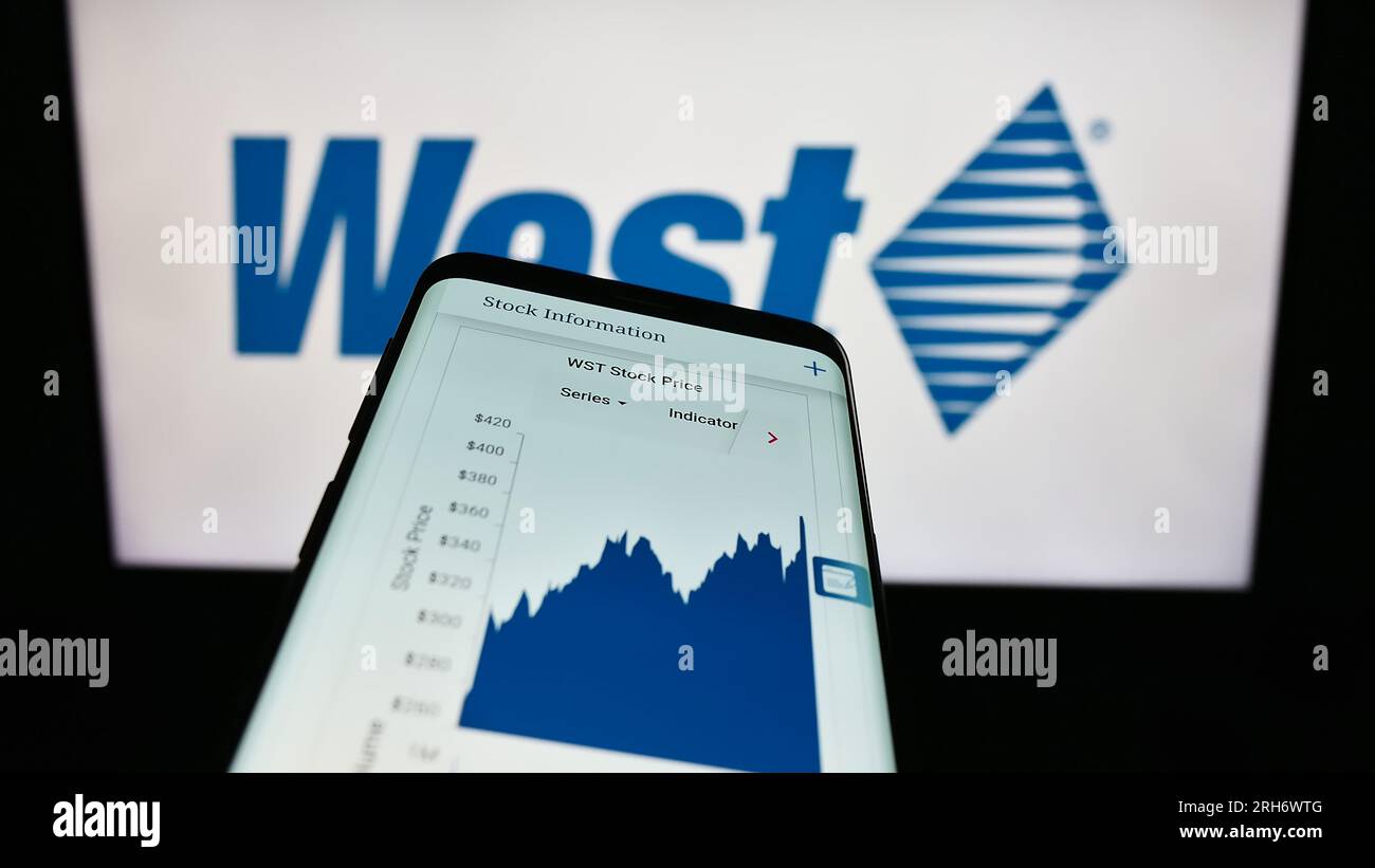 Mobile phone with website of US company West Pharmaceutical Services Inc. on screen in front of business logo. Focus on top-left of phone display. Stock Photo