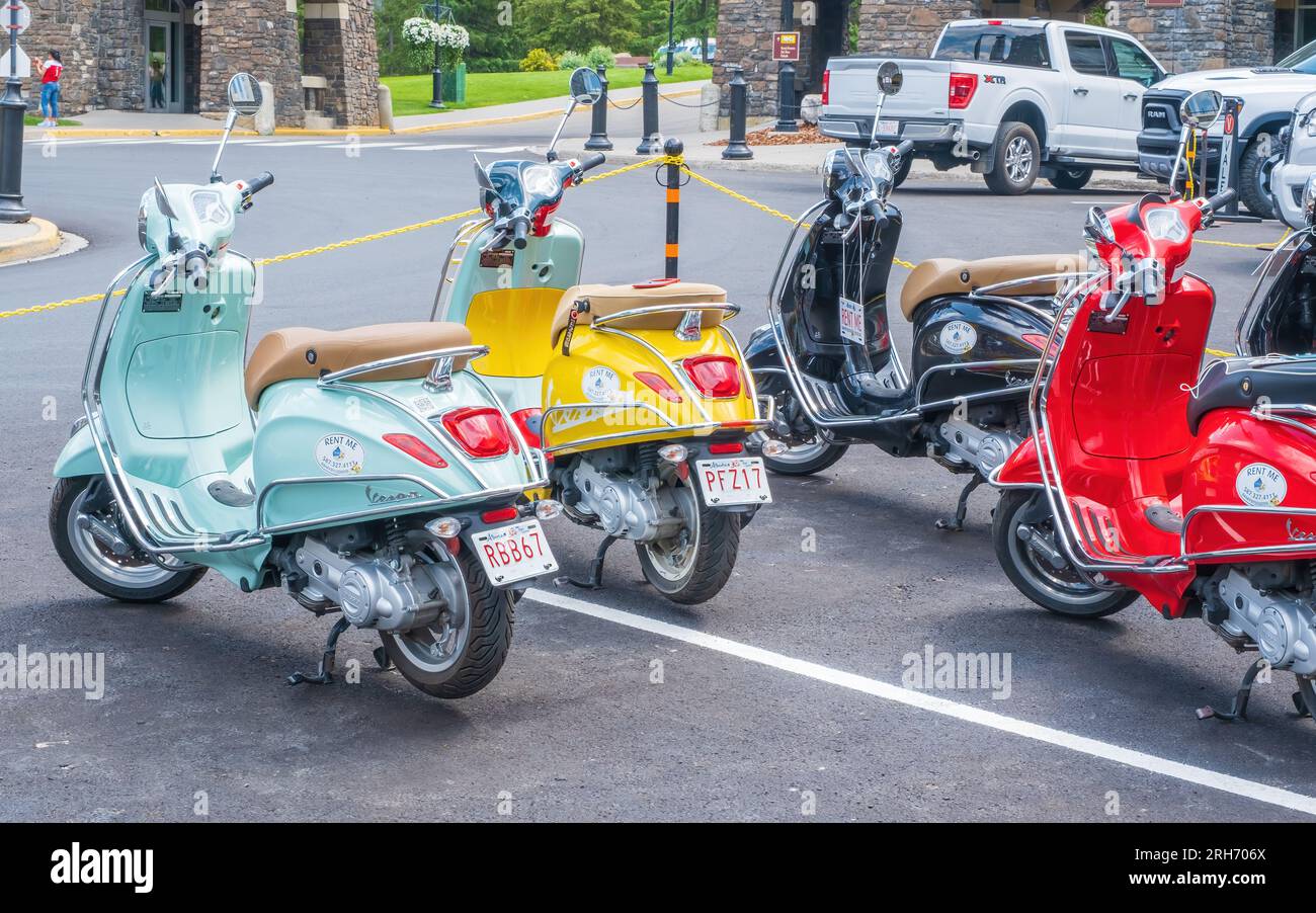 Colourful Vespas available for rent parked in a lot at the Banff