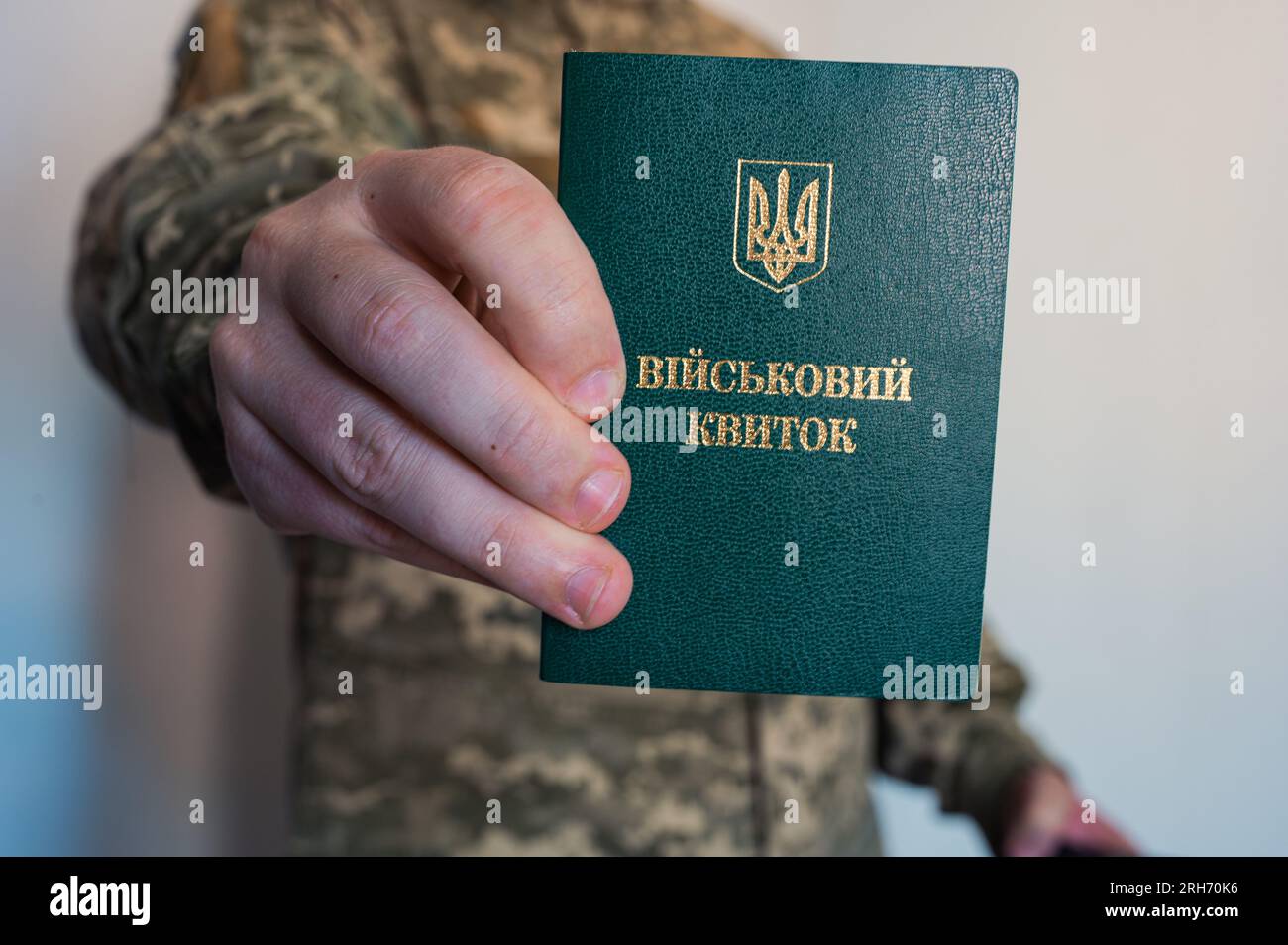 Soldier in camouflage holds military id doc in hand. Ukrainian pixel Stock Photo