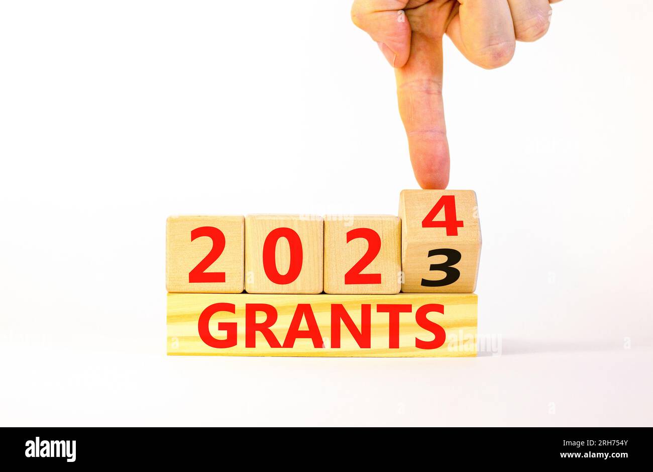 Planning 2024 grants new year symbol. Businessman turns a wooden cube