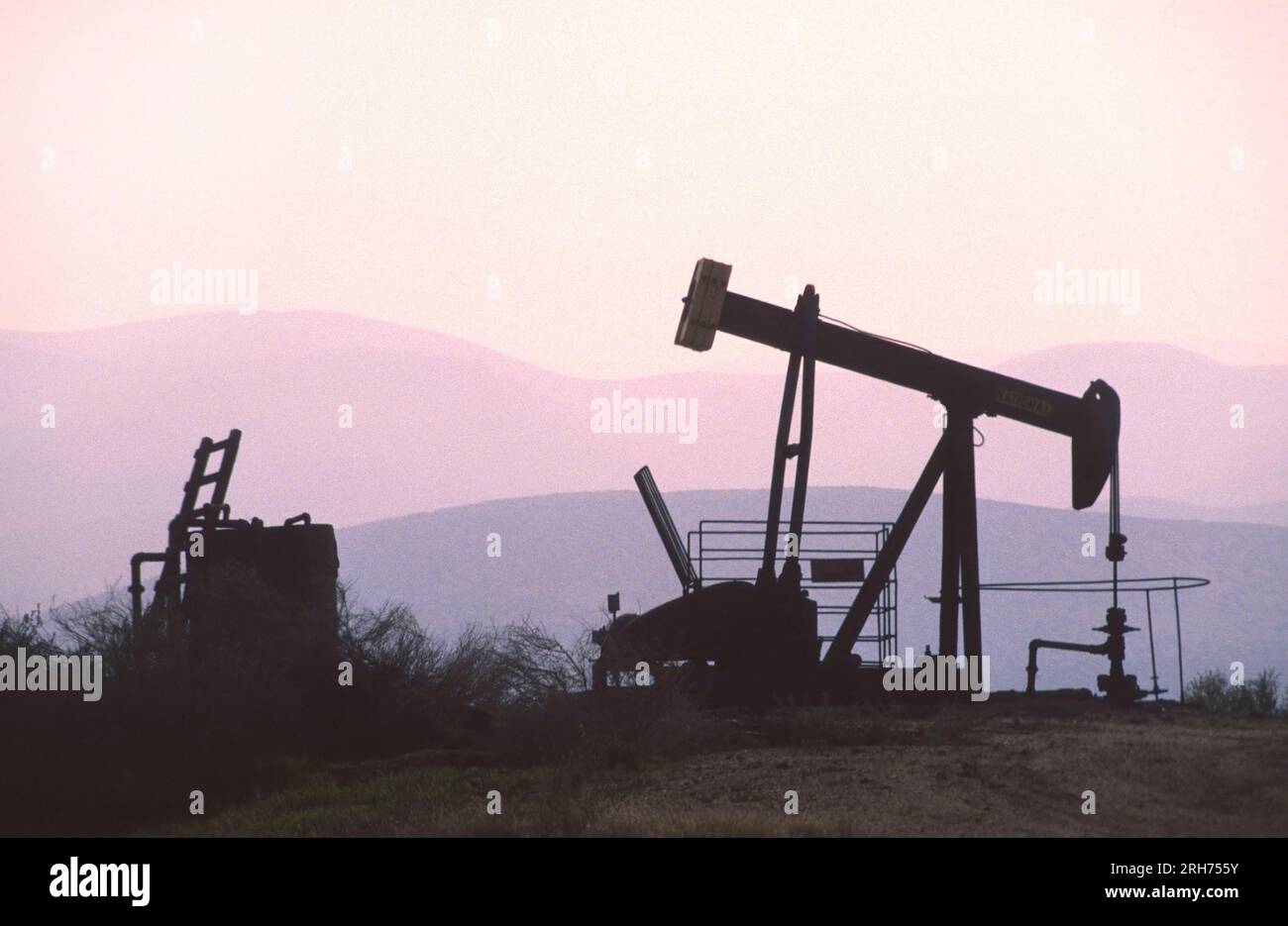 The change in oil prices caused by the war. Oil price cap concept. Oil drilling derricks at desert oilfield. Crude oil production from the ground. Pet Stock Photo
