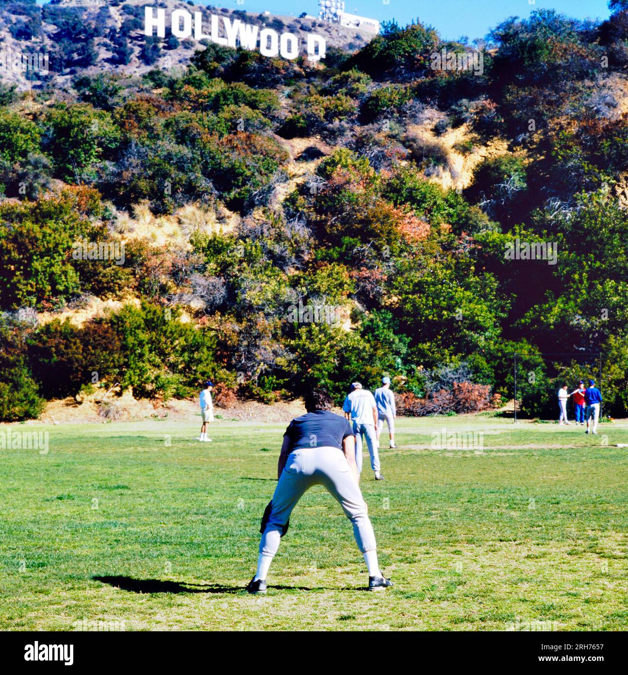 LOS ANGELES, USA- SEPTEMBER 19, 2018: Playing baseball in the park below the Famous Hollywood Sign in Mount Lee in Los Angeles Stock Photo