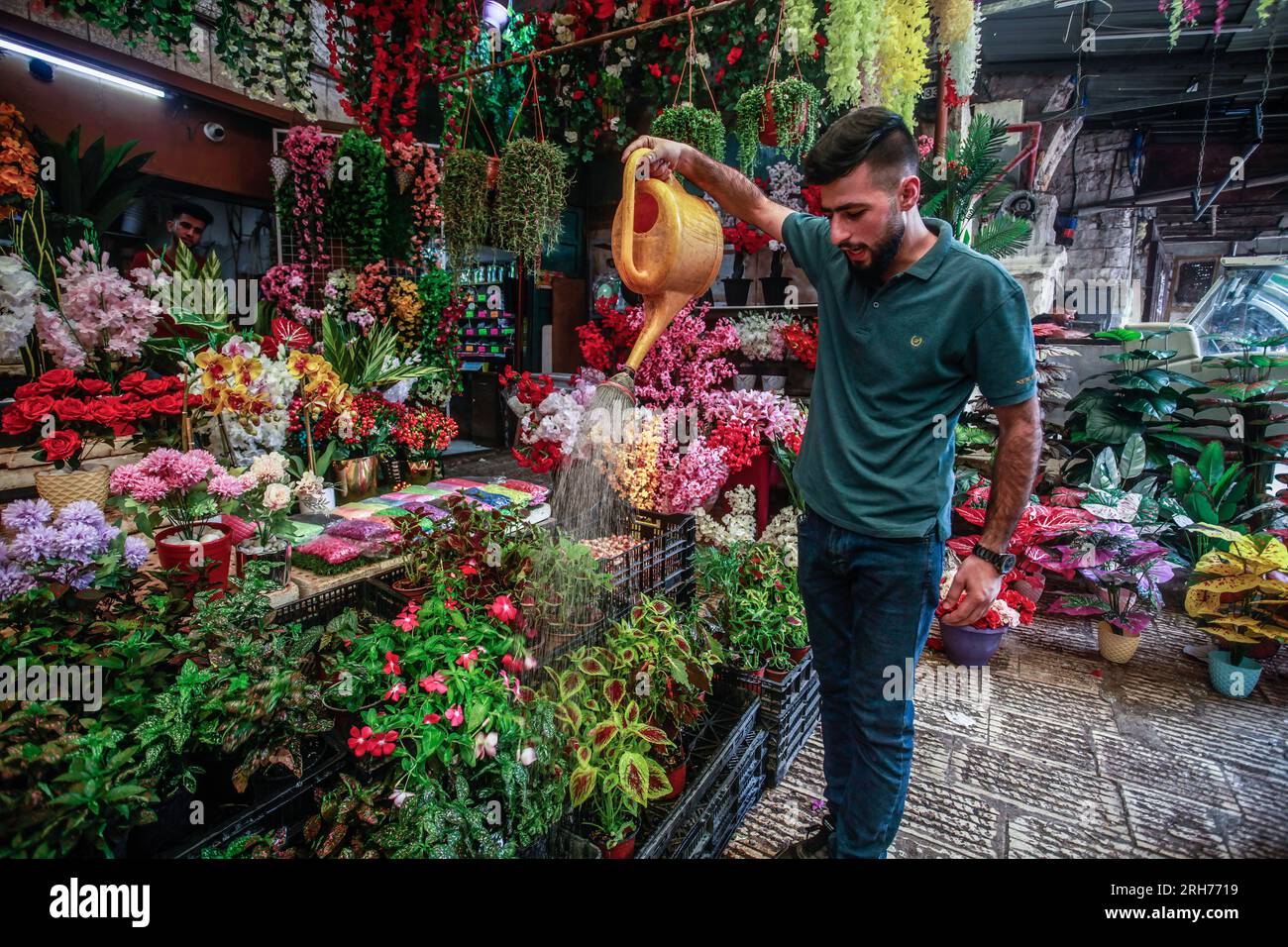 Palestinian Roses Nablus, Palestine. 14th Aug, 2023. A Palestinian shop owner sprays cold ...