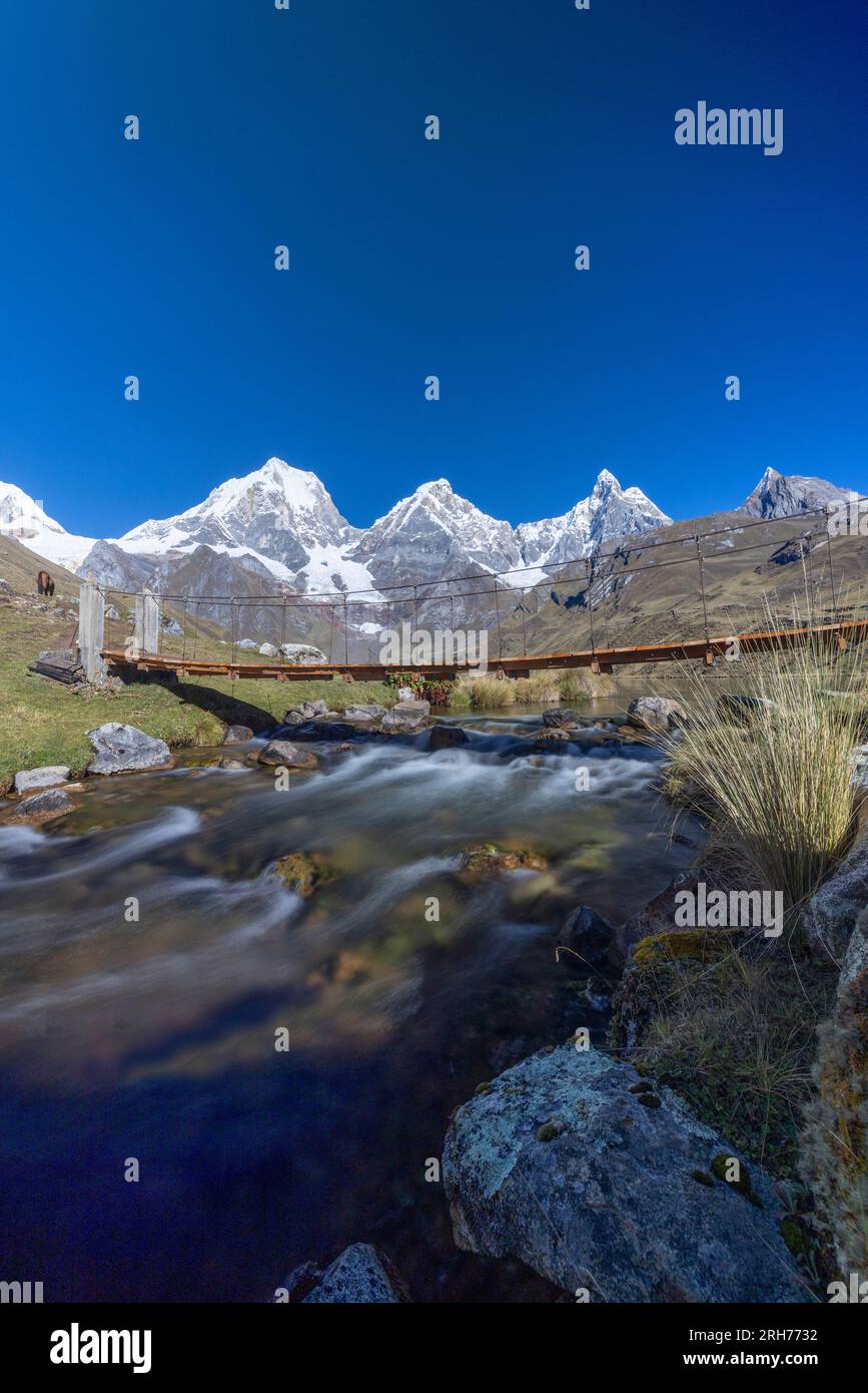 rope bridge over river from lake Carhuacocha, showing Mt Yerupaja Chico ...