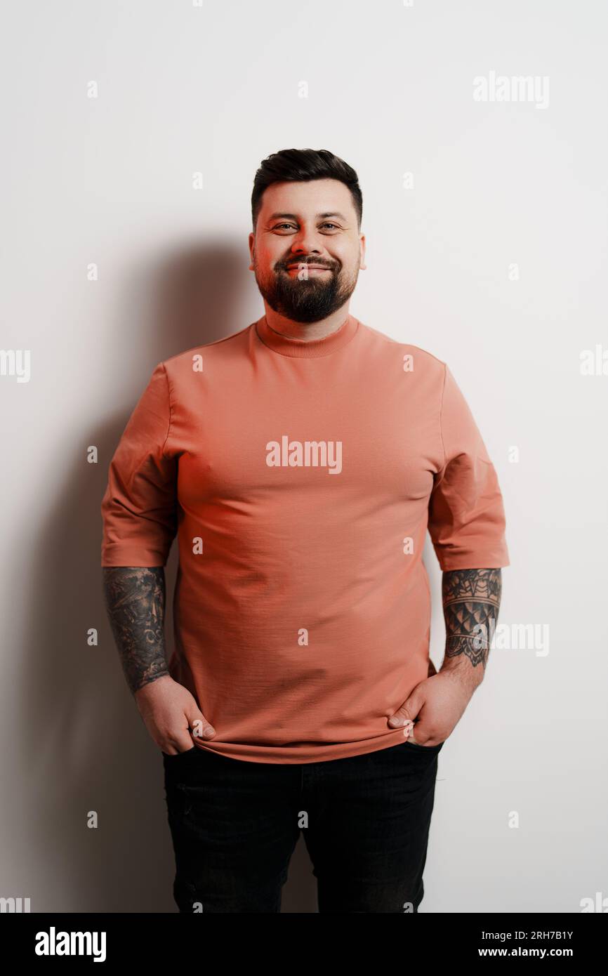 Positive plump man smiling at camera against white background Stock ...